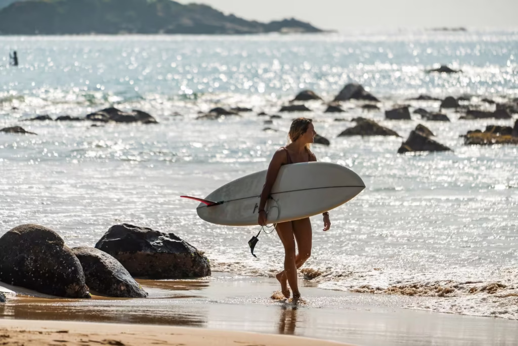Surfers riding a long right-hand point break at Arugam Bay Main Point during the golden hour sunset. Arugam Bay Surf Guide - Surfer at Main PointPrivate Sri Lanka Tours. Best Sri Lanka Surf Guide - Surfer at Sunset